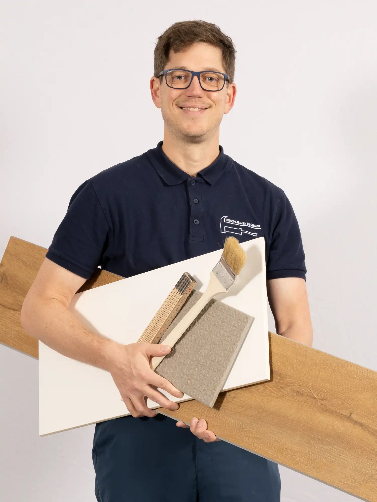 Handwerker Bruno Lienhard mit Werkzeugen und Material in den Händen